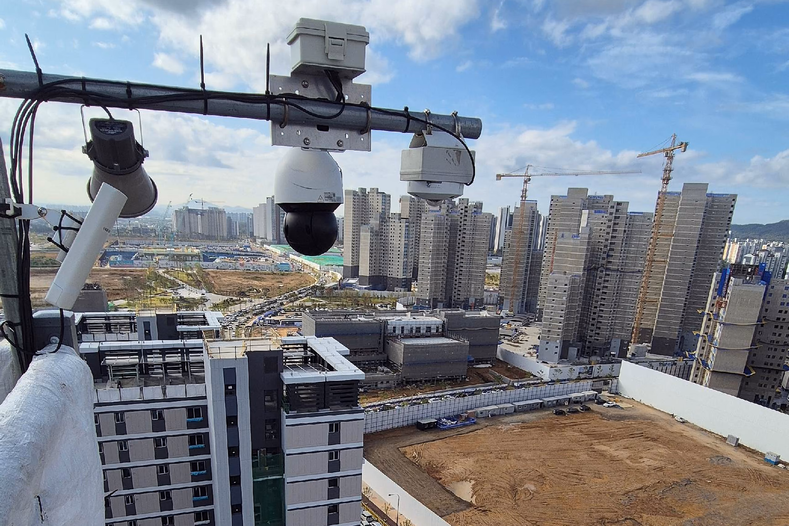 공정 구간에 세운 이동형 CCTV 기둥과 태블릿으로 화면을 보는 작업자
